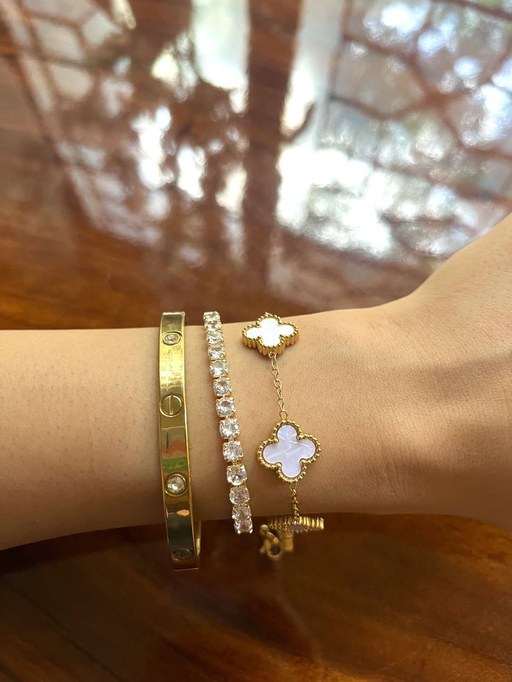 Close-up of a wrist wearing gold and tennis bracelets whiteclover