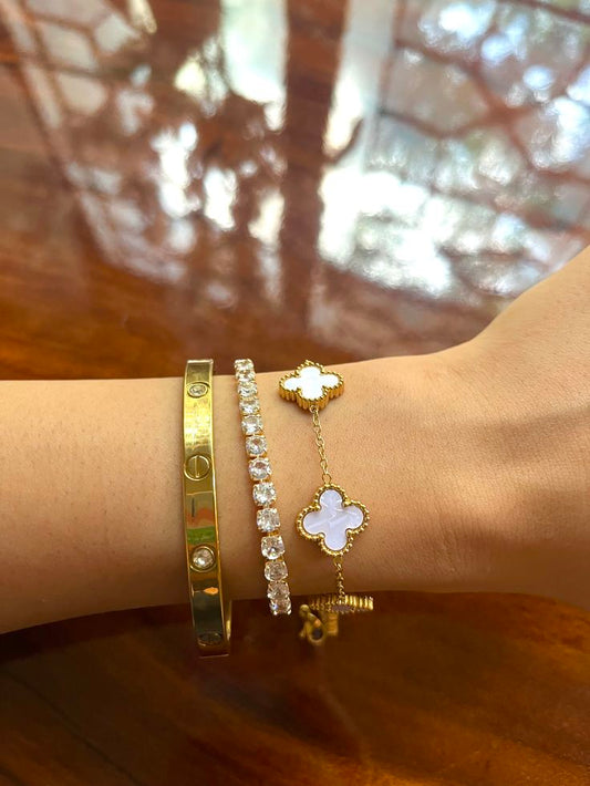 Close-up of a wrist wearing gold and tennis bracelets whiteclover