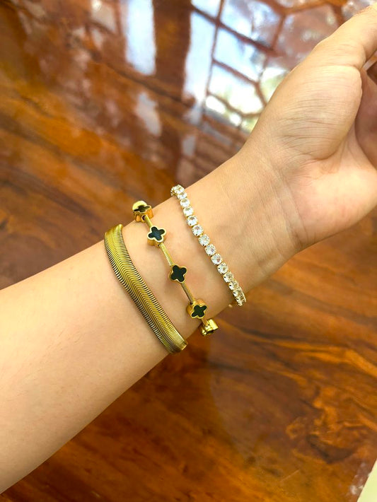 Hand wearing multiple bracelets on a wooden surface