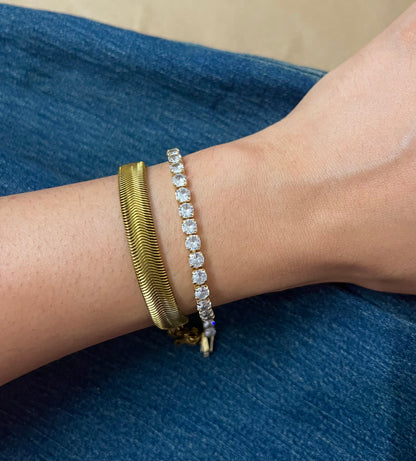 An 18K gold-plated demi-fine stainless steel bracelet stack worn on a person's wrist, featuring two bracelets with one having a link chain design and the other adorned with crystal accents.