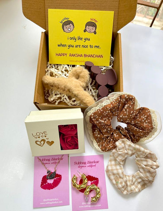 Raksha Bandhan gift set with scrunchies, cards, and other items on a white background