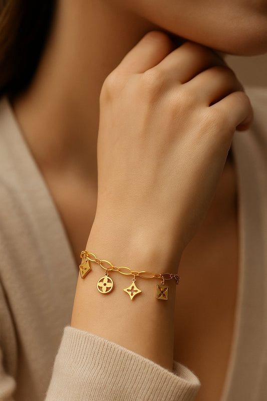 Gold bracelet with charms on a wrist, close-up shot.